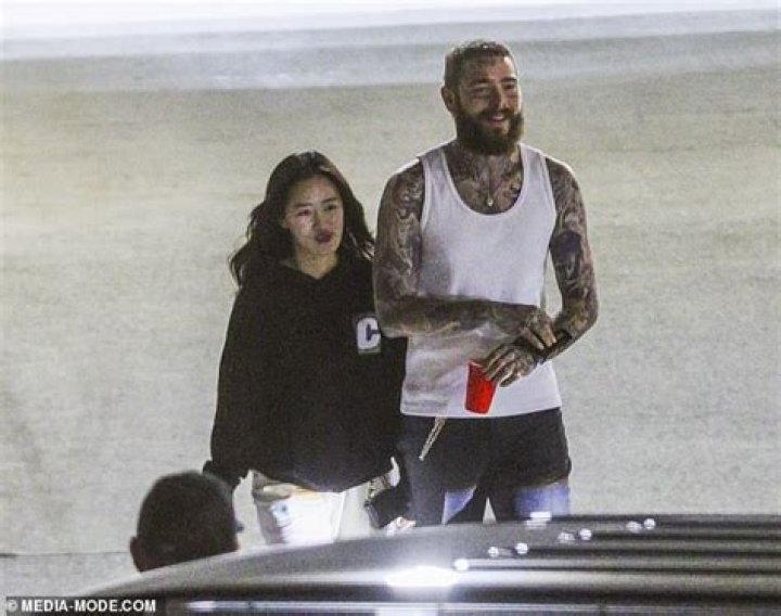 Post Malone waves to fans as he leaves a Sydney stadium with his