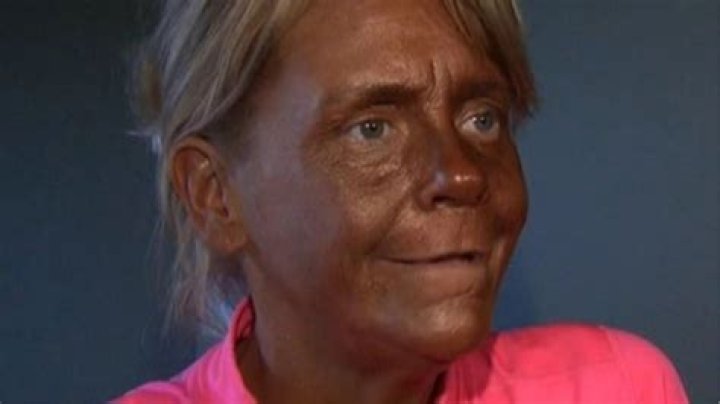 Tanning addict Tan Mom blends into brown couch in wild photo