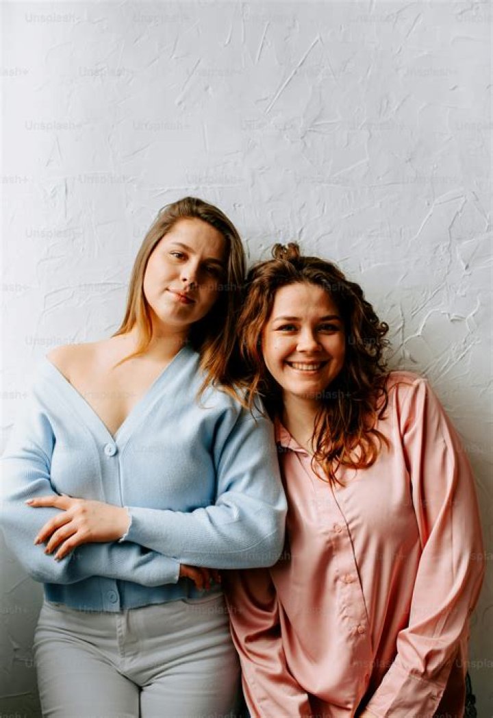 two women standing next to each other smiling